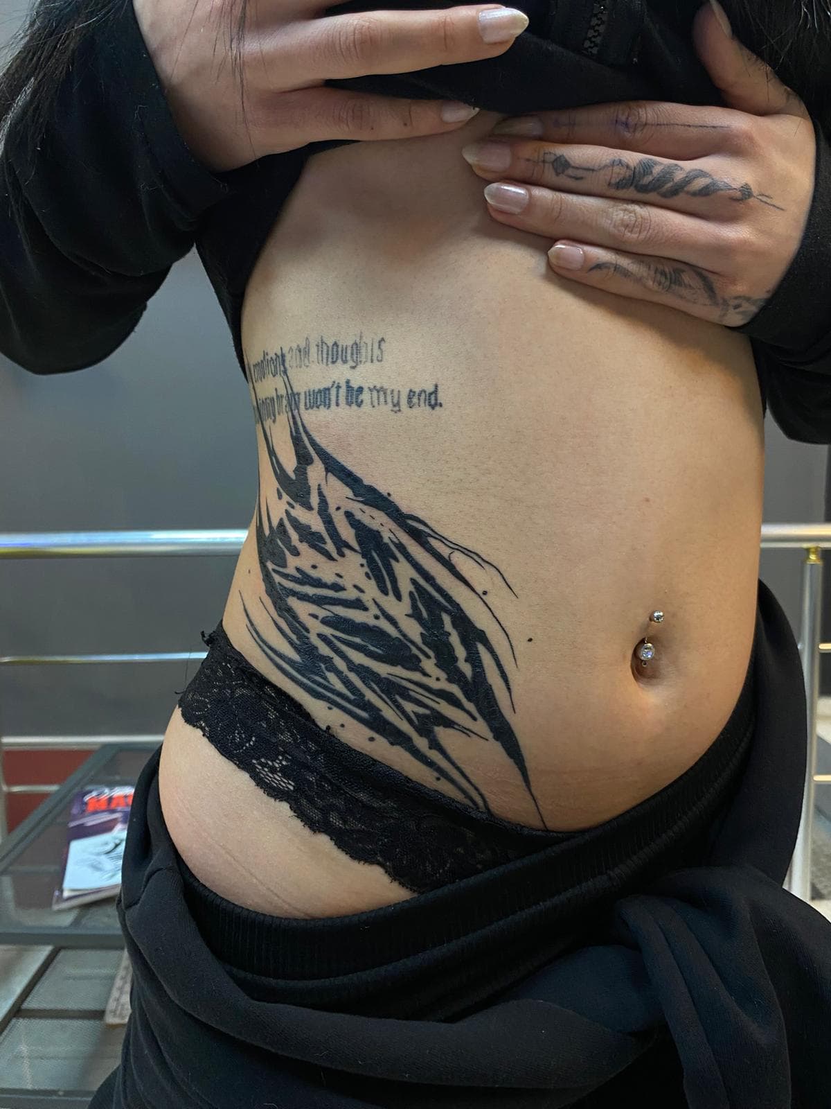 Kaburga bölgesinde kalın siyah soyut fırça darbeleri ve İngilizce yazı — Ersin Tattoo Bakırköy